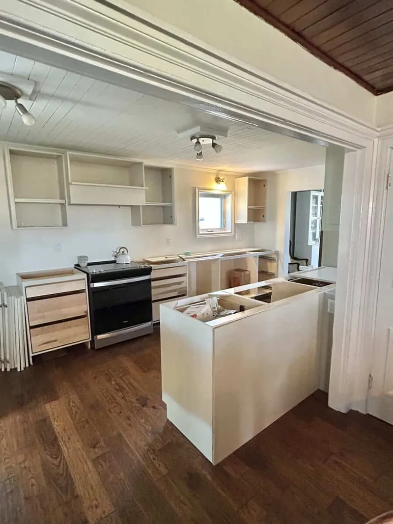 Cabinet installation in progress: maple boxes and drawer banks set and levelled, with doors and counters not yet fitted